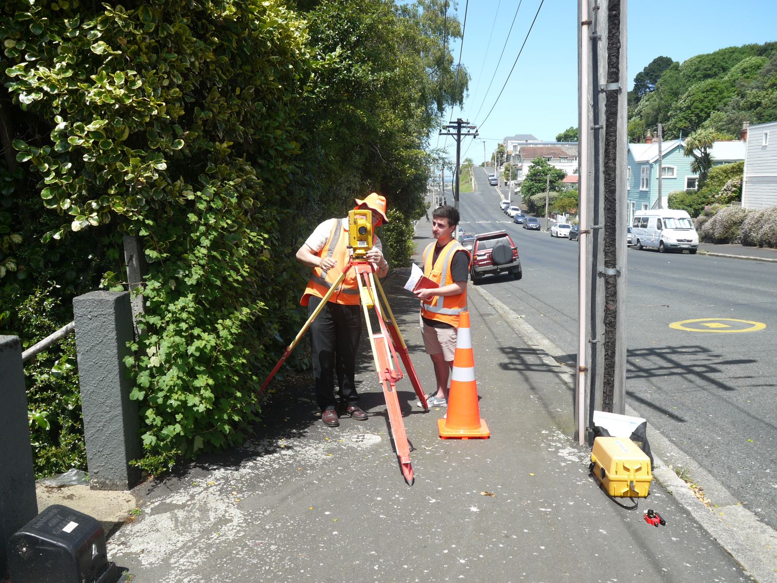 TL Surveys staff with survey equipment on a steep street