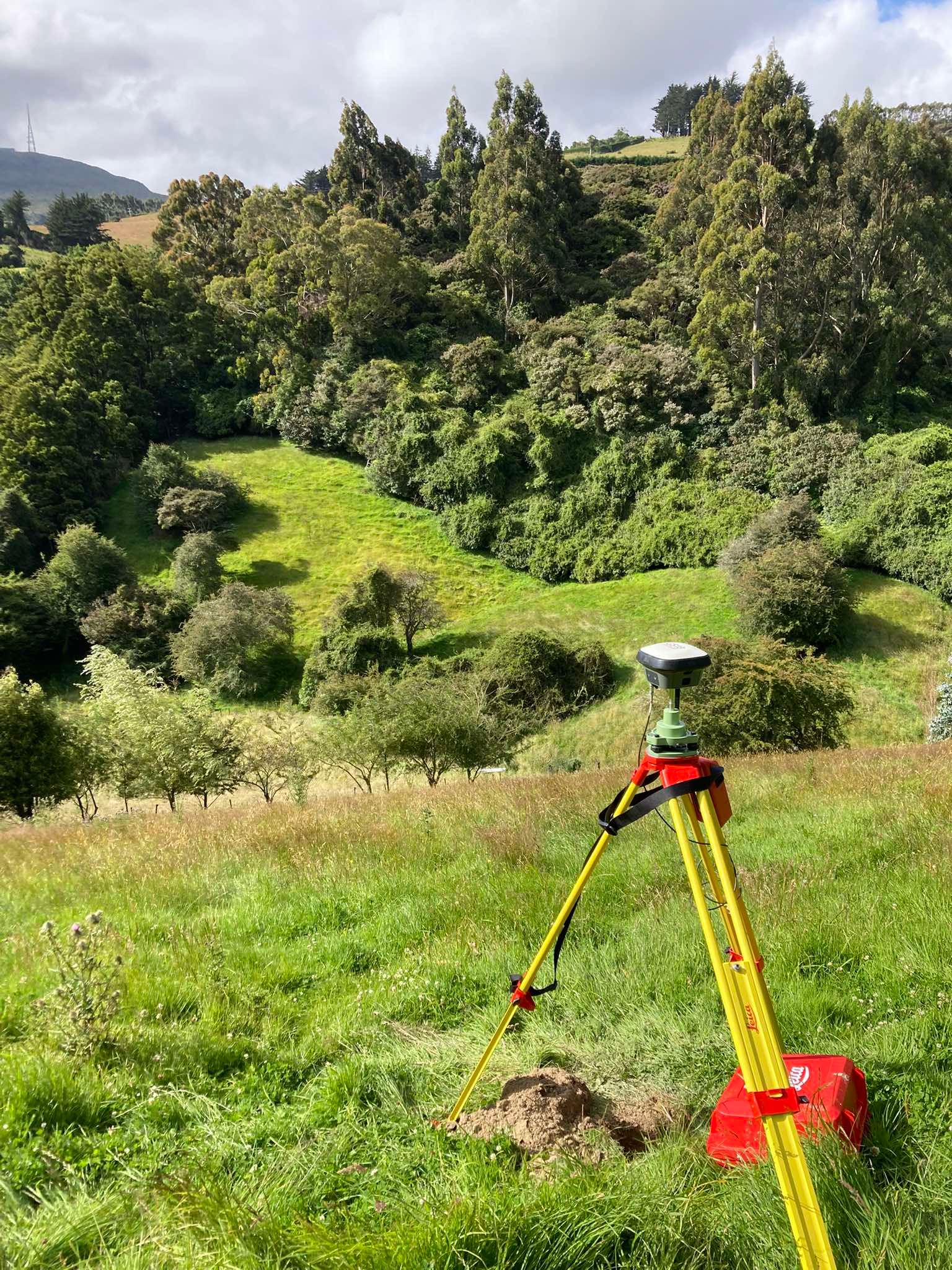Survey equipment set up in farmland and bush